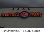 Small photo of Tyler, TX - October 7, 2018: Torchy's Tacos Neon Sign lit during stormy afternoon located on Loop 323 in Tyler TX