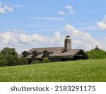 Small photo of The white clouds overtop of the building in the countryside on a sunny day.