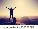 Silhouette of free cheering woman hiker open arms at mountain top cliff edge