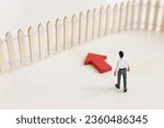 Small photo of Concept image of person facing fence obstacle and thinking about solution. Idea of overcoming barrier and problems