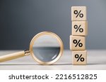 Magnifying glass and stack of wood cubes with percentage icon