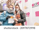 Small photo of New York, NY - December 28, 2021: Tourists from Spain holding paper with message to burn in the incinerator set in Latin America tradition in the middle of Times Square during Good Riddance Day