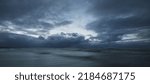 Small photo of Dark storm sky above the Baltic sea, waves and water splashes. Dramatic cloudscape. Nature, environment, fickle weather, climate change. Atmospheric scenery. Panoramic view, long exposure
