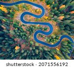 Small photo of Aerial view of winding road in autumn forest. Splendid morning scene of asphalt roadway among fir and larch trees. Highway through the woodland in fall. Traveling concept background.