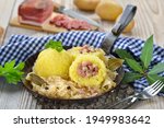 Potato dumplings stuffed with South Tyrolean bacon and served with sauerkraut in an iron pan 