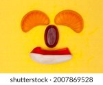 Small photo of A smiling clownish face created with hard and soft sugar candy. Bright saturated colors.