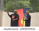 Small photo of LAURA,QLD - JULY 08 2023:Indigenous Australians men carry the Australian Aboriginal Flag in Laura Quinkan Dance Festival Cape York Queensland Australia.The flag have special legal and political status