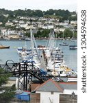 Small photo of Kingswear, Devon, UK. June 17, 2009. A yachtsman walking along the jetty with yachts and yacht masts lined up on the river Dart with Dartmouth in the background taken from Kingswear in Devon, UK.