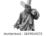 Ancient stone statue of Jesus Christ with cross isolated on white background. Free copy space.