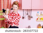 Small photo of Pretty pin-up girl teenager smarten up on a pink kitchen. Beauty, youth fashion. Pin-up style.