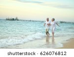 Old couple running on sea beach
