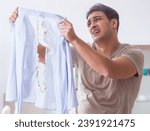 Small photo of Inattentive husband burning clothing while ironing