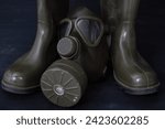 Small photo of An old gas mask amidst military rubber boots, a haunting reminder of past conflicts and the imperative to protect oneself against threats.