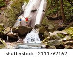 Family with child at waterfall. Travel with kids. Little boy hiking and trekking at jungle river. Summer vacation on exotic island. Active hike with young children. Adventure fun.