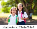 Small photo of Kids go back to school. Interracial group of children of mixed age run and cheer on the first day of new academic year. Start of school holiday. Preschooler or kindergarten kid. Child in school yard.