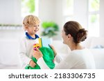Small photo of Child going back to school. Mother and kid getting ready for first school day after vacation. Little boy and mom going to kindergarten or preschool. Student packing books, apple and lunch in backpack.