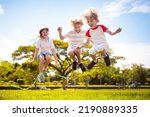 Small photo of Happy kids play outdoor. Children skipping rope in sunny garden. Summer holiday fun. Group of school children playing in park playground. Healthy outdoors activity. Sport for child.