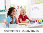 Small photo of Kids go back to school. Interracial group of children of mixed age in classroom. Students learn to read and write. Preschooler or kindergarten kid with teacher. Child learning letters with flash cards
