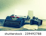 old typewriter and vintage photo camera on wooden background. retro style toned picture