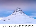 Kirkjufell mountain, Iceland. Winter natural landscape. The mountain ont he sky background. Snow and ice. A popular place to travel in Iceland.