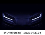 Silhouette of black sports car with LED headlights on black background, copy space	