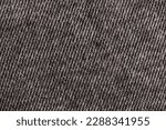 Small photo of part of jeans sewn from high-quality gray denim, close-up and details of natural denim from which jeans pants are sewn
