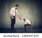 Small photo of Big businessman giving a hand supporting a depressed desperate little entrepreneur
