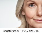 50s middle aged old woman looking at camera isolated on white background advertising dry skin care treatment anti age skincare beauty, plastic surgery, cosmetology procedures. Close up half face view