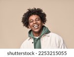 Small photo of Happy joyful young African American hipster guy isolated on beige background. Smiling funny ethnic teen student, cool curly gen z fashion model laughing with dental smile white teeth, portrait.