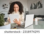 Small photo of Young happy latin woman, smiling curly casual girl student using digital tablet and laptop elearning or hybrid working at home online looking at tab technology device sitting at table in living room.