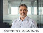 Happy mid aged older business man executive standing in office. Smiling 50 year old mature confident professional manager, confident businessman investor looking at camera, headshot close up portrait.