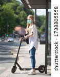 Small photo of Casual caucasian teenager commuter waering protective face mask against spreading of corona virus with modern foldable urban electric scooter waiting for metro city bus. Urban mobility concept.