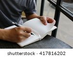  man write pen on notebook near window ,hand writing pen on paper page,hardworking for achievement business target concept, write idea by pen.
