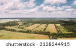 Small photo of Aerial View Spring Green Field With Windbreaks Landscape. Top View Of Field And Forest Belt. Drone View Bird's Eye View. A Windbreak Or Shelterbelt Is A Planting Usually To Protect Soil From Erosion.