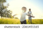 Small photo of happy family kids. people in park children child running together in the park at sunset silhouette. mom dad daughter and son are run happy family and little child in fun summer. dream kids run