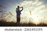 Small photo of father and son in the park. father day silhouette happy family child dream concept. father carries his son on his back. dad playing with his son in nature in the park silhouette at sunset lifestyle