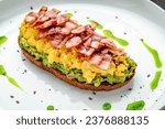 Small photo of Scramble on toast with bacon, guacamole and olives. Healthy and tasty breakfast on a plate
