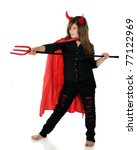 Small photo of A pretty preteen dressed as a she-devil taking aim with her pitchfork. Isolated on white.