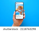 Mobile phone on blue background with shared photo on sample social media app