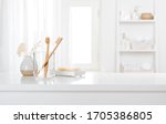 Small photo of Table with toothbrushes and soap inside a bright defocused bathroom
