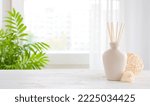 Small photo of Wooden table and incense sticks vase on blurred window background
