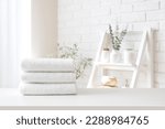 Spa towel stack on white table on bathroom interior background