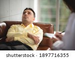 Psychotherapist is helping,listening and supporting her depressed patient at indoor office.  Healthcare treatment concept of professional psychologist doctor consult for depressed client