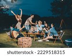 Young hipster people having fun to music dining and drinking together in campsite - Travel vacation lifestyle and youth culture concept, Happy friends group toasting beers at barbecue camping party