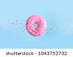 one pink flying sweet doughnut with sprincles on blue