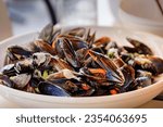 Small photo of Freshly cooked mussels steamed in white wine sauce or moules marinieres on a plate at a restaurant in Nice Old Town, French Riviera, South of France