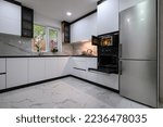 Small photo of A bright and airy kitchen with a white, modern design and a luxurious marble floor. The open oven door adds a touch of warmth and comfort.