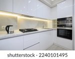 Small photo of White modern kitchen with a stove, oven and microwave, glass electric kettle at worktop