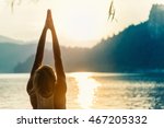 Beautiful woman practicing Yoga by the lake - Sun salutation series - Upward hands pose - Toned image