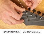 Small photo of Putting new string on an electric guitar, string changing and tuning